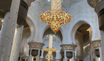 Grand Mosque interior with chandeliers and columns.