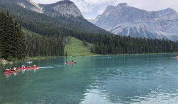 A lake surrounded by mountains with people canoeing.