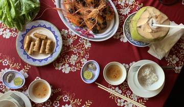 Vietnamese dishes arranged on a table with decorative cloth.
