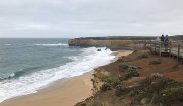 A coastal landscape with a sandy beach and cliffs.