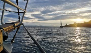 Sailboat on the ocean during sunset.