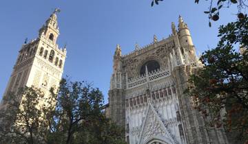 Catedral de Sevilla with ornate details and trees in foreground.