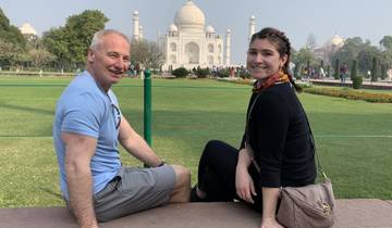 Two people sitting with the Taj Mahal in the background.