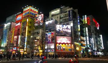 Vibrant city scene at night with illuminated buildings and signs.