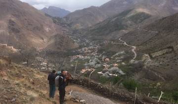 Panoramic view of mountain village surrounded by hills.