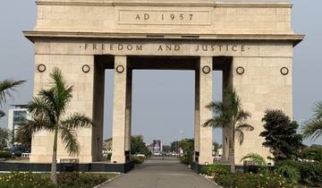 Independence Arch with palm trees and cityscape in the background.