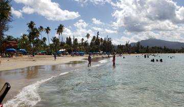 A beach filled with people enjoying the sun and sea.