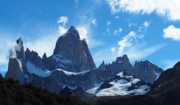 Majestic mountain peaks with snow under a blue sky.