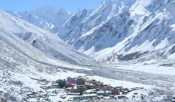 Snow-covered village nestled in a dramatic mountain landscape.