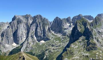 Mountainous landscape with rocky peaks and green valleys.