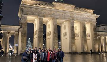 Group of people posing in front of an iconic, illuminated monument at night.
