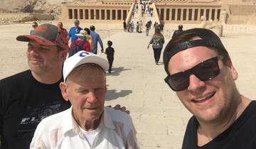Group selfie outside an ancient temple with crowds in the background.