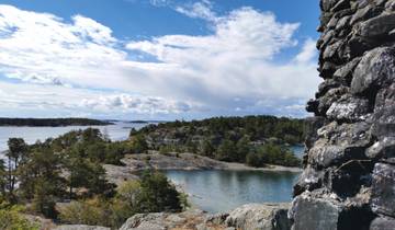 Rocky islands with trees and water under a partly cloudy sky.