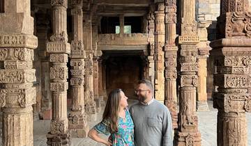 Couple standing among intricately carved stone pillars.
