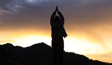 Silhouette of a person practicing yoga at sunset.