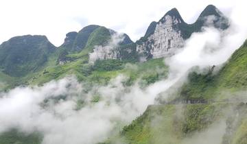 Misty mountains with clouds in a lush green landscape.
