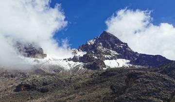 Snow-capped mountain peak with clouds.