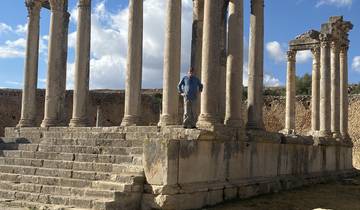 Ruins of an ancient structure with a person standing on the steps.