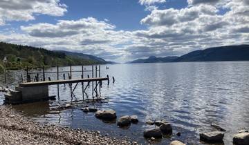 Dock on a calm lake with surrounding hills.
