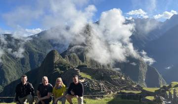 People posing with Machu Picchu visible in the background.