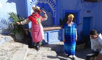 People in traditional attire in a blue-themed area