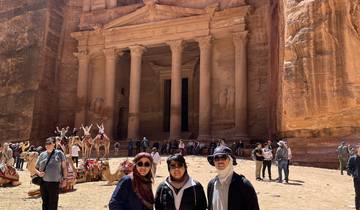 Visitors posing in front of the ancient rock-cut architecture.