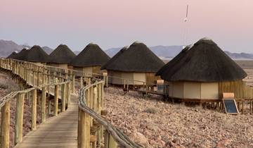 Row of thatched-roof huts at sunset.