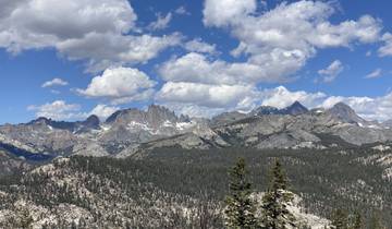 Mountain range with snow-capped peaks under blue skies.
