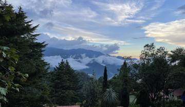 Scenic view of mountains with clouds and trees