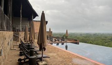 Chairs and umbrellas by an infinity pool.