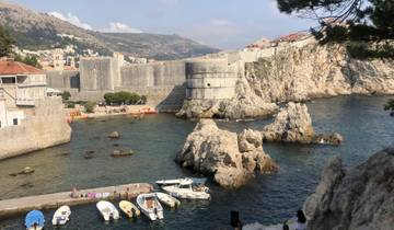 Fortified city walls next to the sea with nearby buildings.