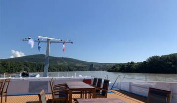View from a boat on a river with hills in the background.