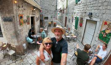 Couple taking a selfie in a quaint street cafe.