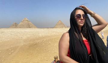 Person posing with pyramids in Egypt.