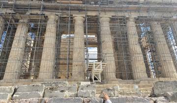 Ancient Greek structure under restoration with scaffolding.