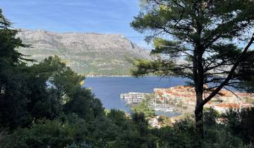 View of a coastal town with mountains and sea in the background.