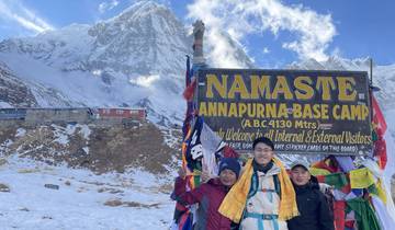 Group of people at the Annapurna Base Camp with mountain in the backdrop.