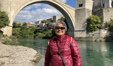 Woman standing in front of a landmark bridge.