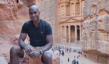 Person sitting in front of the Petra Treasury in Jordan.