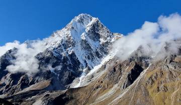 Tall snow-covered mountain under a clear blue sky.