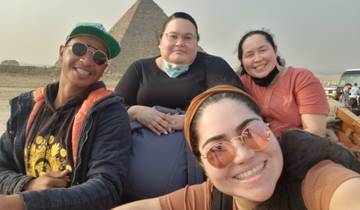 Group selfie with pyramids in the background in Egypt.