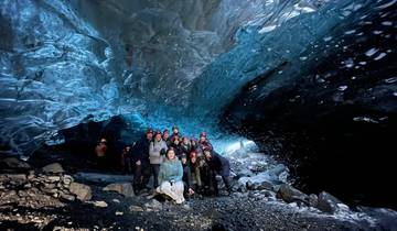 A group in an ice cave wearing warm clothing.