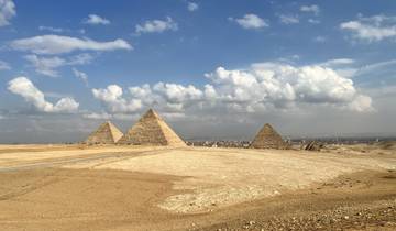 The Pyramids of Giza under a cloudy sky.