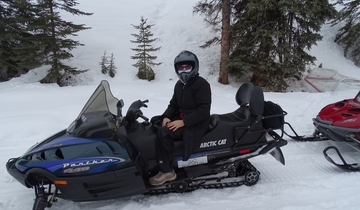 A person on a snowmobile in the snow.