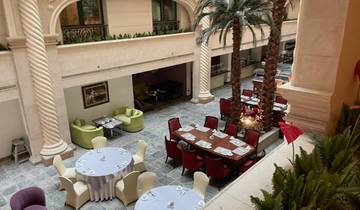 Hotel atrium with dining tables and trees.