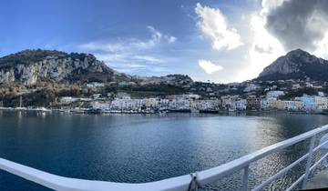 Panoramic view of a coastal town with mountains and a harbor.