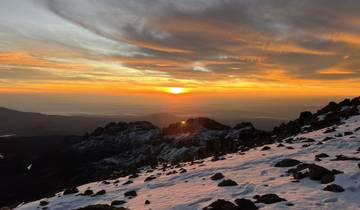 A stunning sunset over a snowy mountainous landscape.