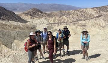 Group of people posing with a desert landscape in the background.