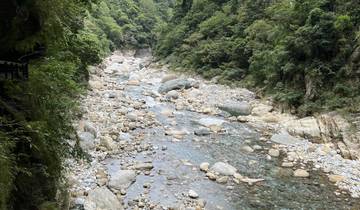 Rocky riverbed in a green valley.