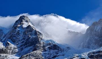 Snow-covered mountains with clouds above.